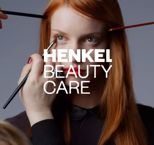 henkel logo in front of woman doing make up